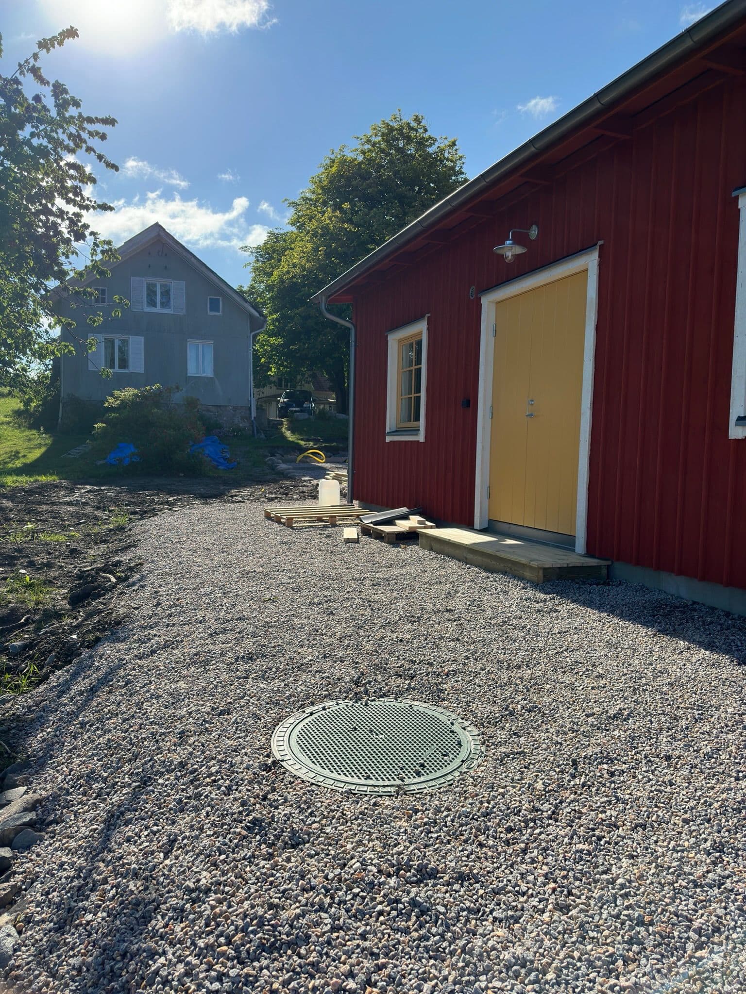 Färdig installation av avloppsanläggning vid en röd byggnad